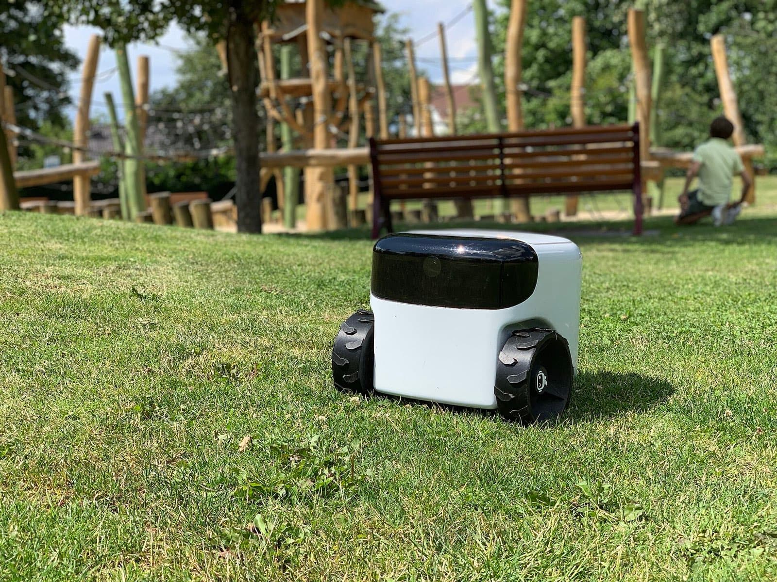 Kompakter Mähroboter auf einer Parkwiese